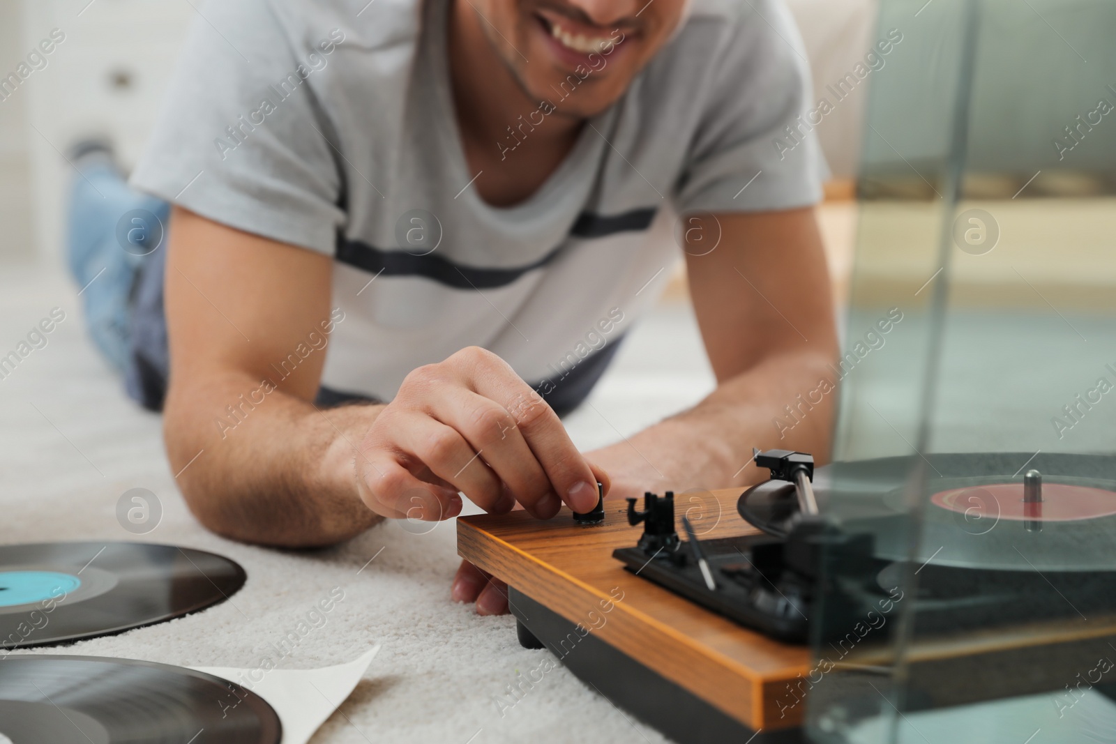 Photo of Happy man using turntable at home, closeup