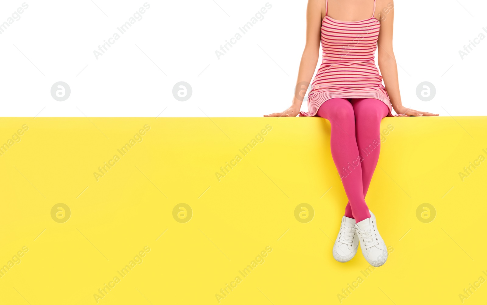 Photo of Woman wearing pink tights sitting on color background, closeup. Space for text