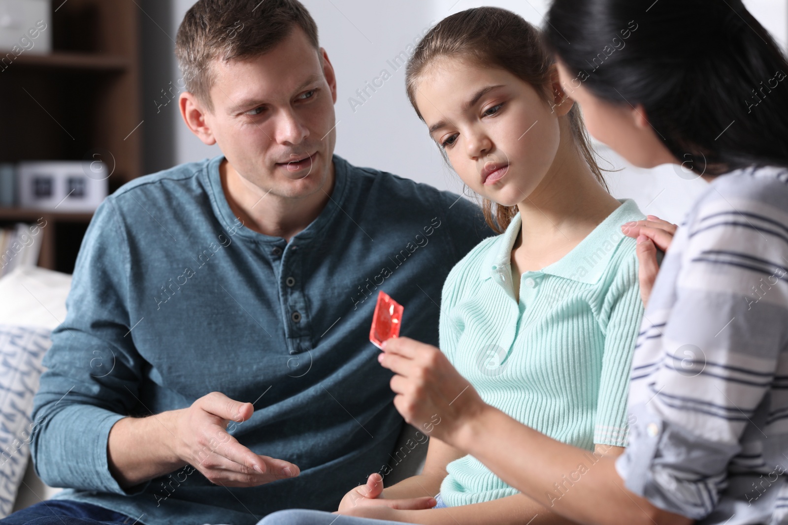 Photo of Parents talking with their teenage daughter about contraception at home. Sex education concept