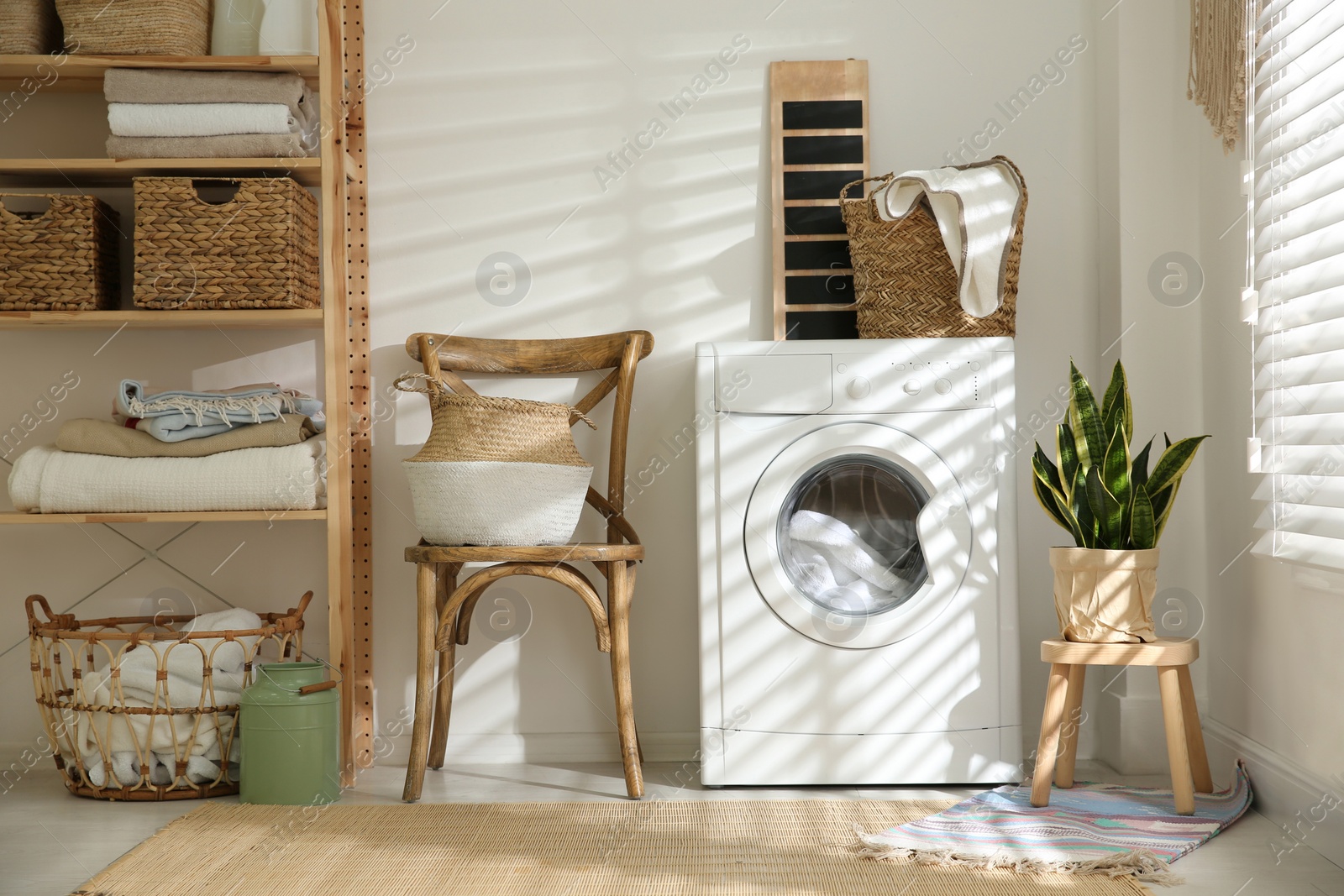 Photo of Modern washing machine in laundry room interior