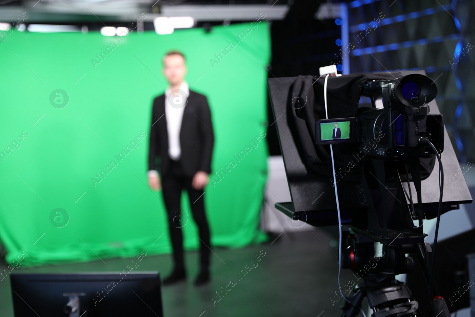 Photo of Presenter working in studio, focus on video camera