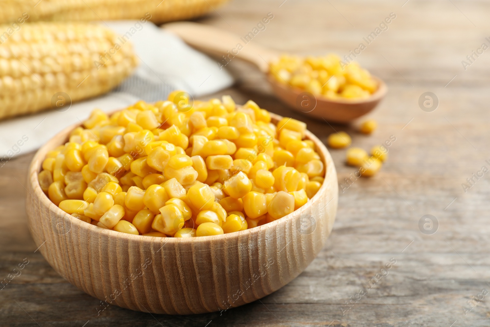 Photo of Delicious canned corn on wooden table, closeup