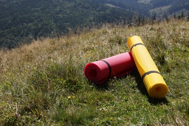 Photo of Rolled sleeping pads on grass in mountains, space for text