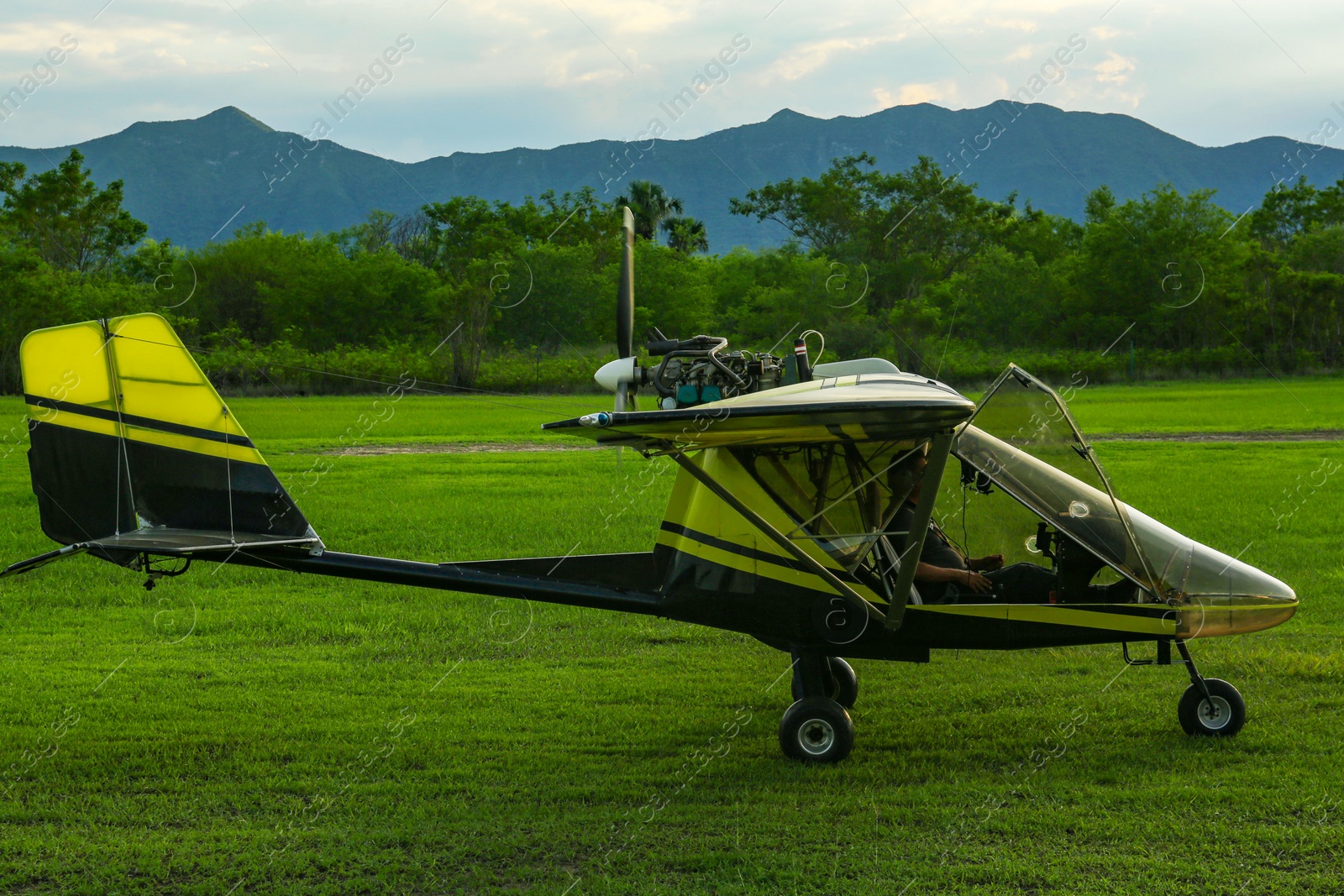 Photo of Modern colorful airplane on green grass outdoors