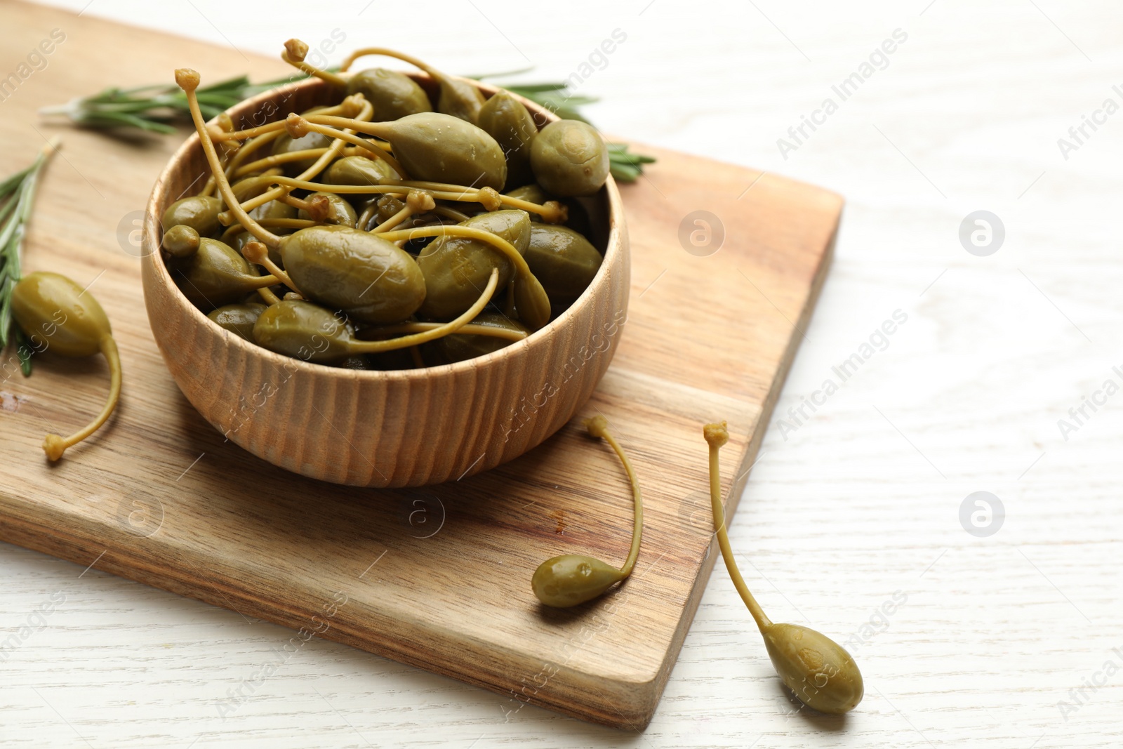 Photo of Tasty capers on white wooden table, space for text