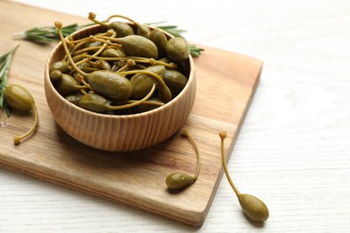 Photo of Tasty capers on white wooden table, space for text