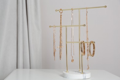 Photo of Interior element. Holder with set of luxurious jewelry on white table