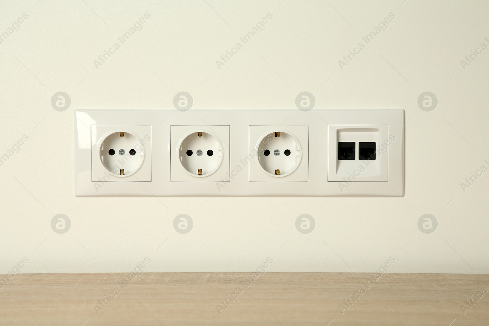 Photo of Many power sockets with ethernet plate on white wall indoors