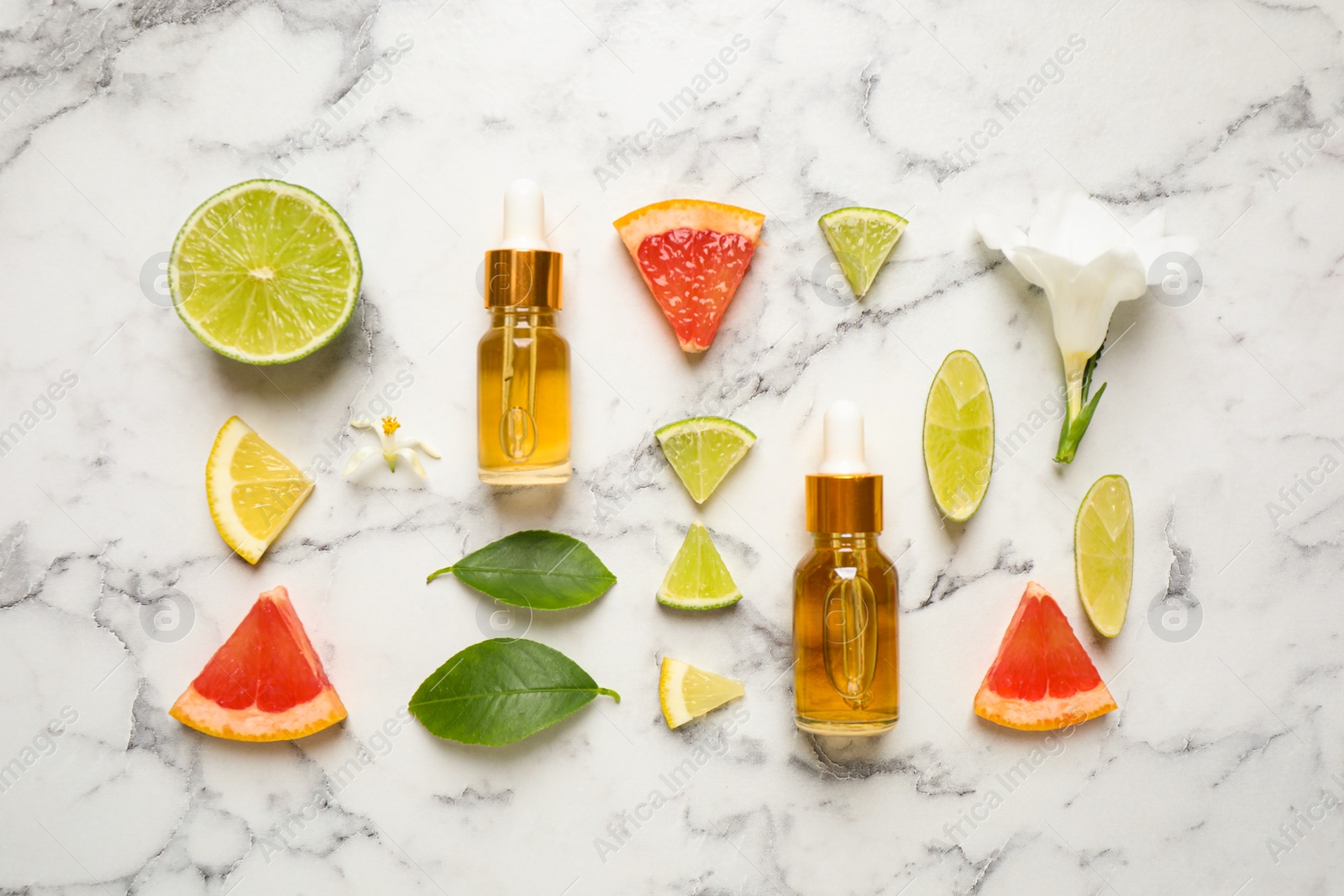 Photo of Flat lay composition with bottles of citrus essential oil on white marble background