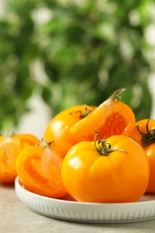 Photo of Fresh ripe yellow tomatoes on light table outdoors, closeup