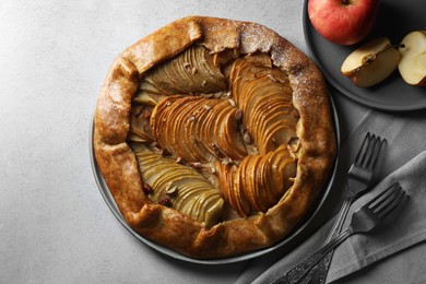 Delicious galette with apples served on light grey textured table, flat lay
