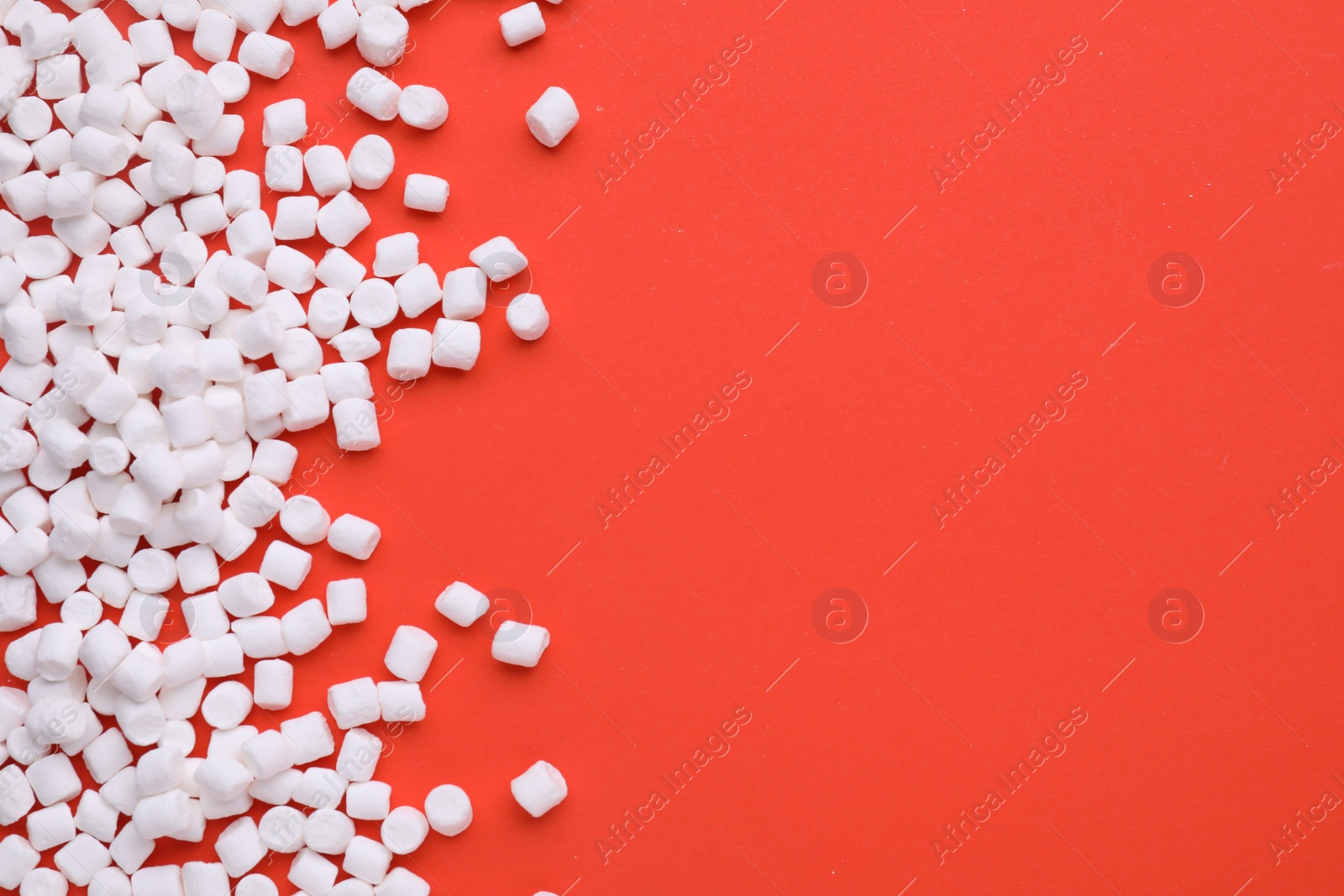 Photo of Delicious marshmallows on red background, flat lay. Space for text