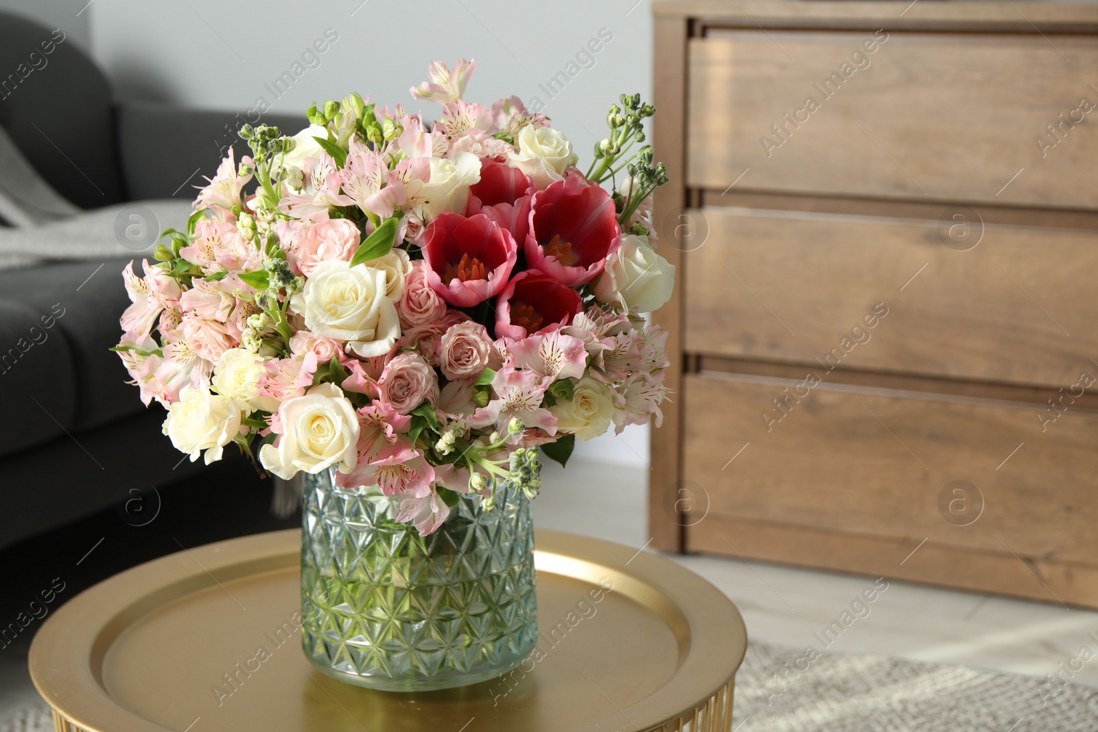 Photo of Beautiful bouquet of fresh flowers on coffee table in room, space for text