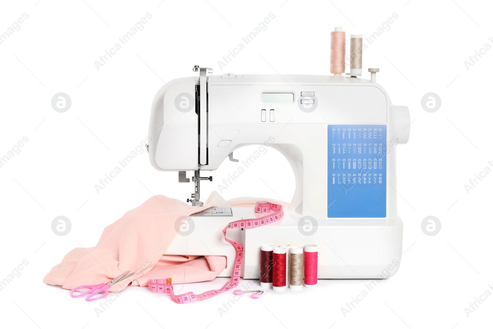 Photo of Modern sewing machine with pink cloth and craft accessories isolated on white