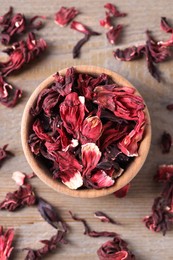 Photo of Dry hibiscus tea on wooden table, flat lay