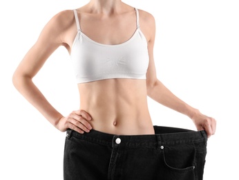 Photo of Young slim woman wearing oversized jeans on white background, closeup