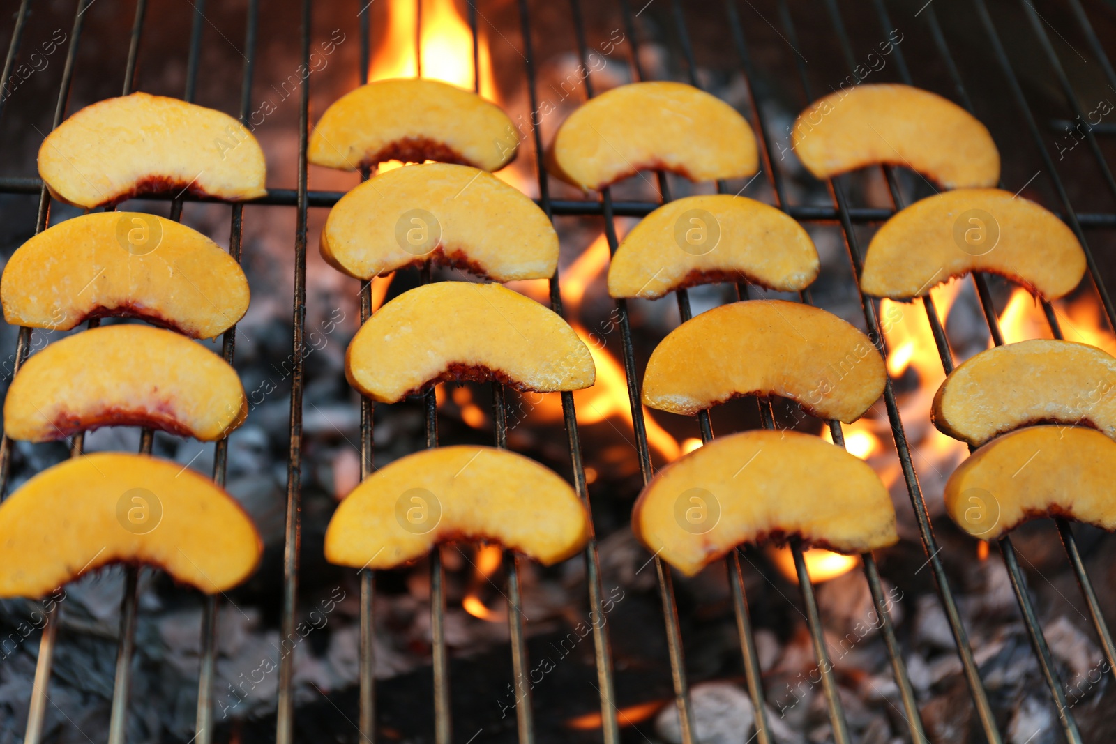 Photo of Modern grill with tasty peach slices, closeup