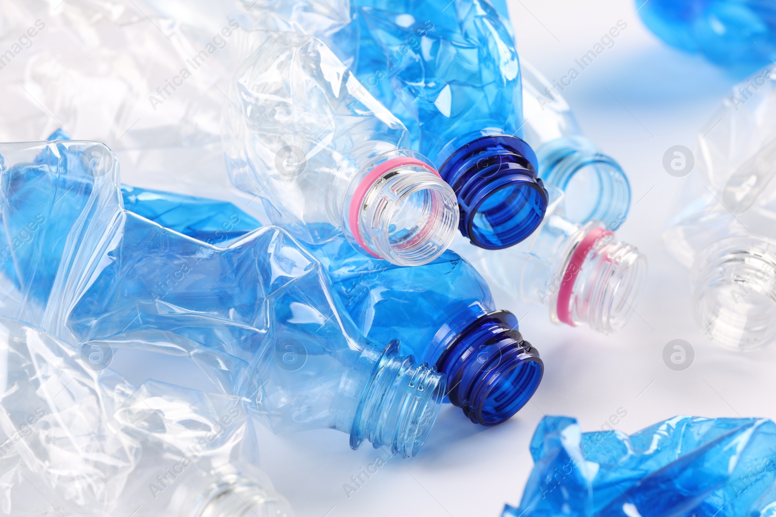 Photo of Crumpled disposable plastic bottles on white background