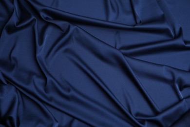 Photo of Crumpled dark blue silk fabric as background, top view