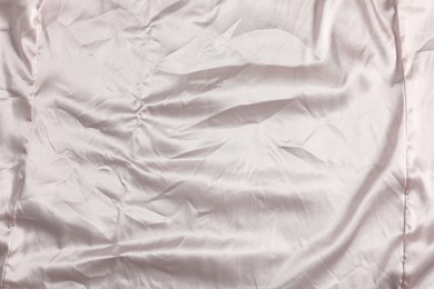 Photo of Crumpled light pink fabric as background, top view