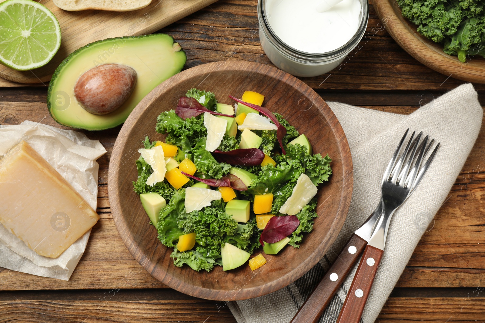 Photo of Delicious kale salad served on wooden table, flat lay