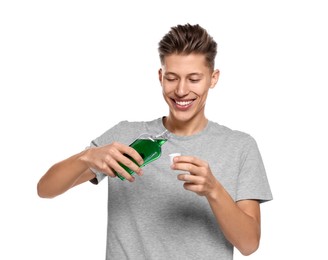 Young man with mouthwash on white background