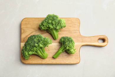Photo of Fresh green broccoli on light marble table, top view