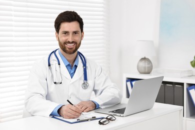 Medical consultant with stethoscope at table in clinic