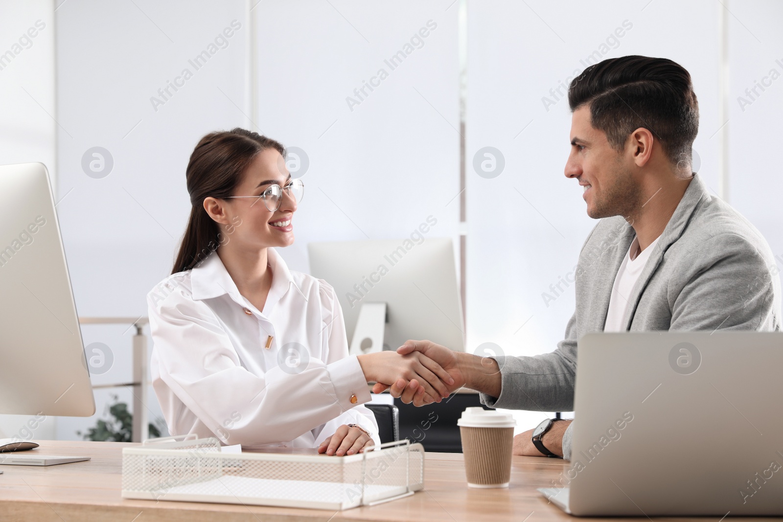 Photo of Employee shaking hands with intern in office