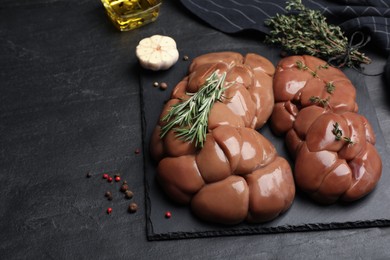 Fresh raw kidneys with seasonings on black table, space for text