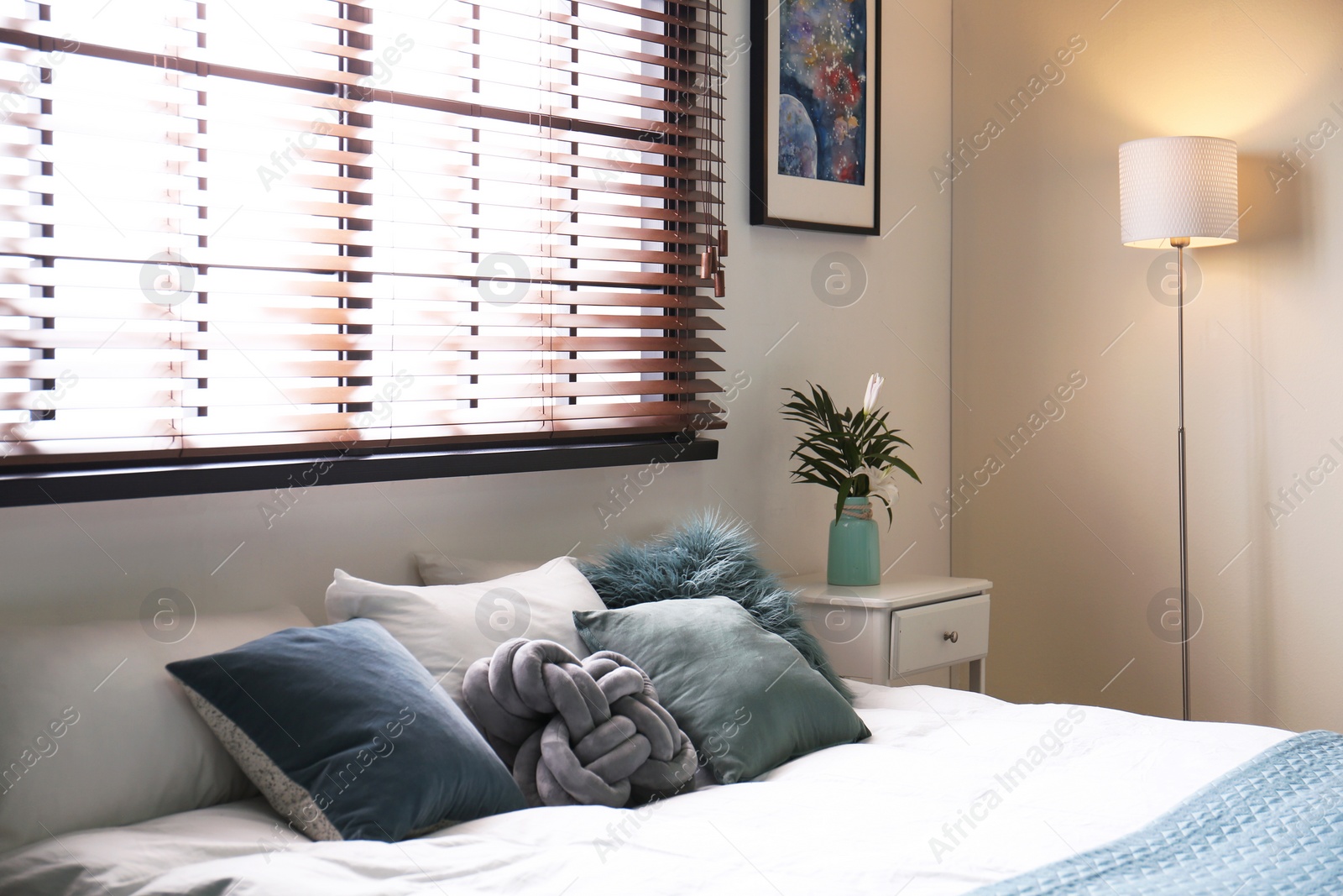 Photo of Modern room interior with comfortable double bed and window blinds