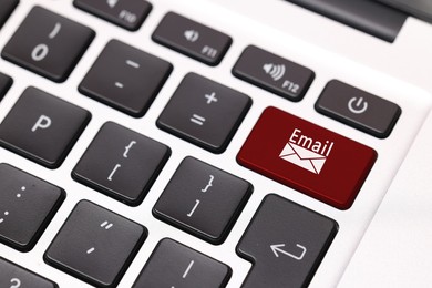 Red button with word Email and illustration of envelope on laptop keyboard, closeup