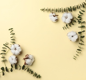 Flat lay composition with cotton flowers on yellow background. Space for text