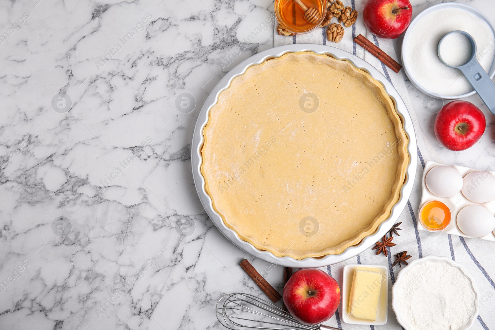 Photo of Raw dough and traditional English apple pie ingredients on white marble table, flat lay. Space for text