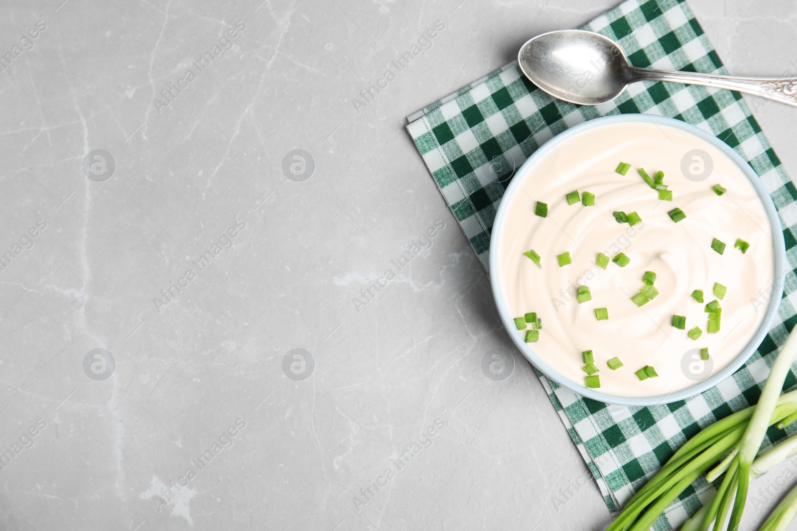 Photo of Fresh sour cream with onion on grey marble table, flat lay. Space for text