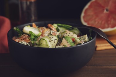 Photo of Delicious pomelo salad with shrimps served on wooden table, closeup