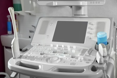 Photo of Modern ultrasound machine in clinic, space for text