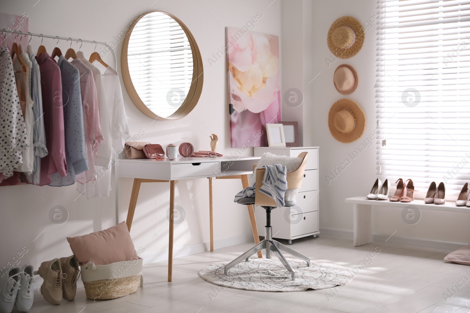 Photo of Dressing room interior with stylish makeup table, clothes and accessories