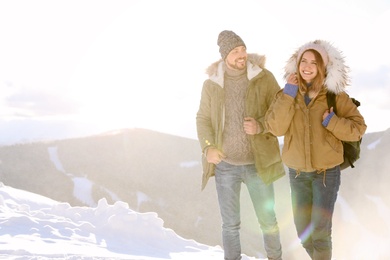 Happy couple spending winter vacation together in mountains. Space for text