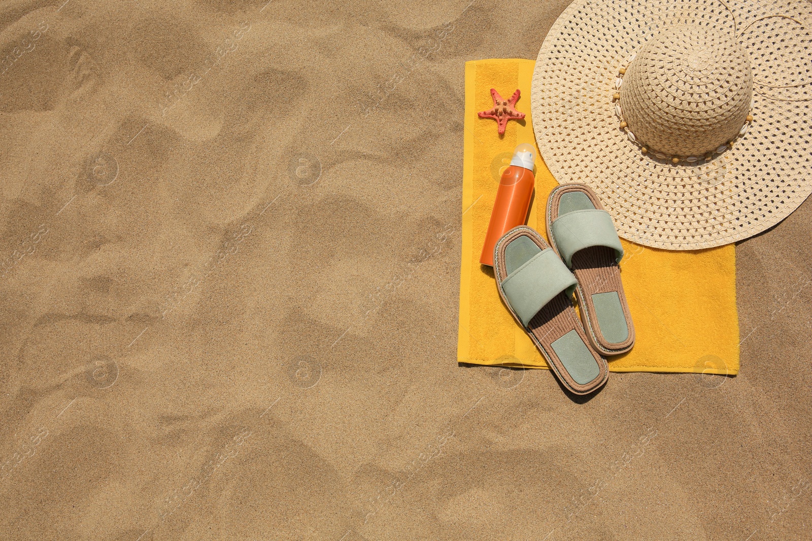 Photo of Sunscreen, starfish and beach accessories on sand, top view with space for text. Sun protection care