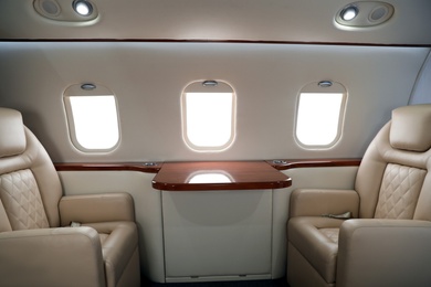 Image of Airplane cabin with comfortable seats and table