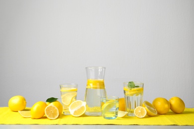 Photo of Composition with lemon water and fresh fruits on table