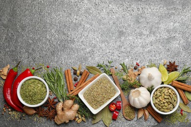 Photo of Flat lay composition with different natural spices and herbs on grey table, space for text