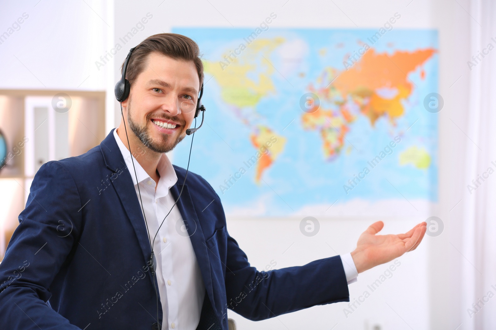 Photo of Male consultant with headset in travel agency. Space for text