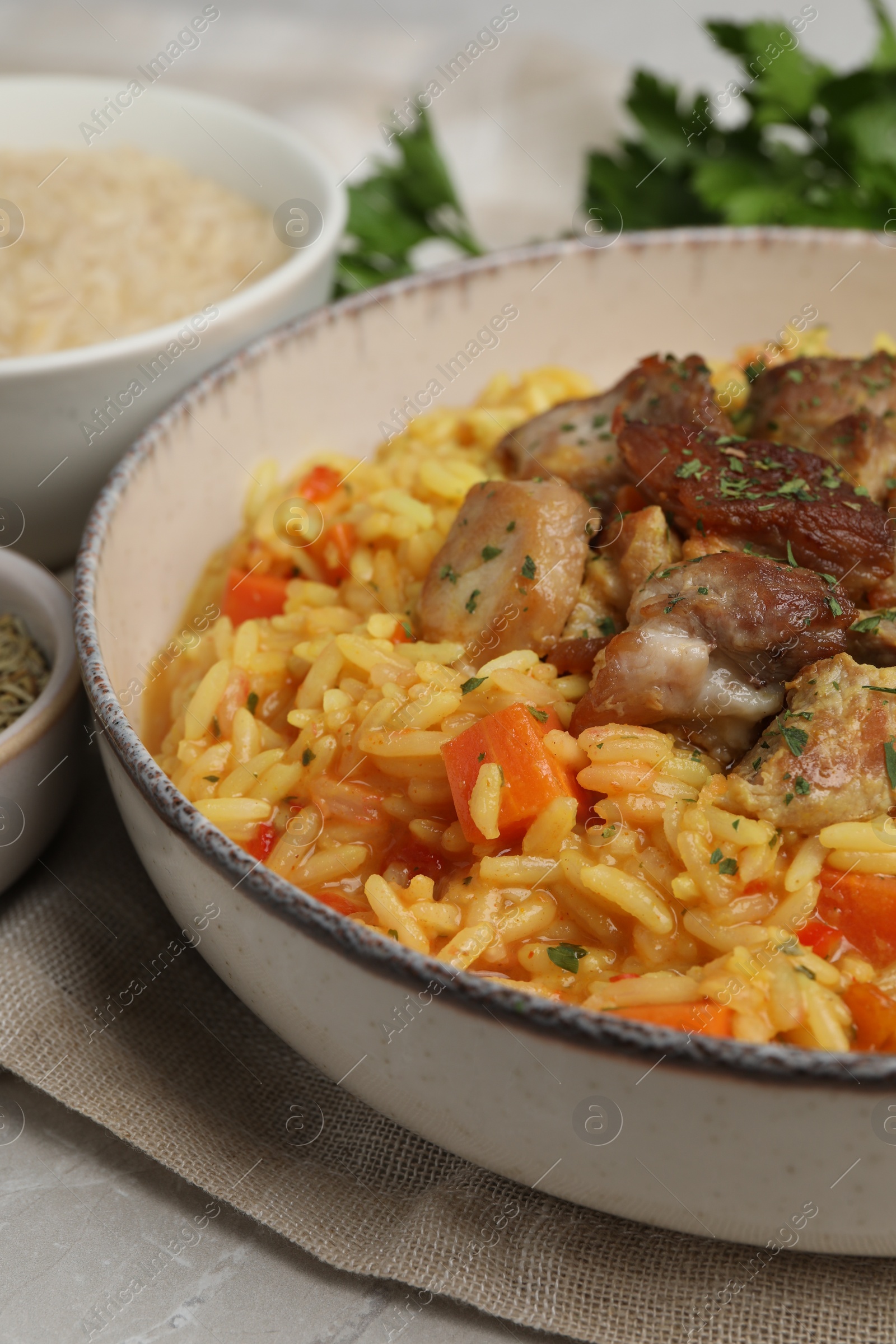 Photo of Delicious pilaf with meat on light grey table, closeup