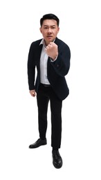 Angry businessman in suit posing on white background, low angle view