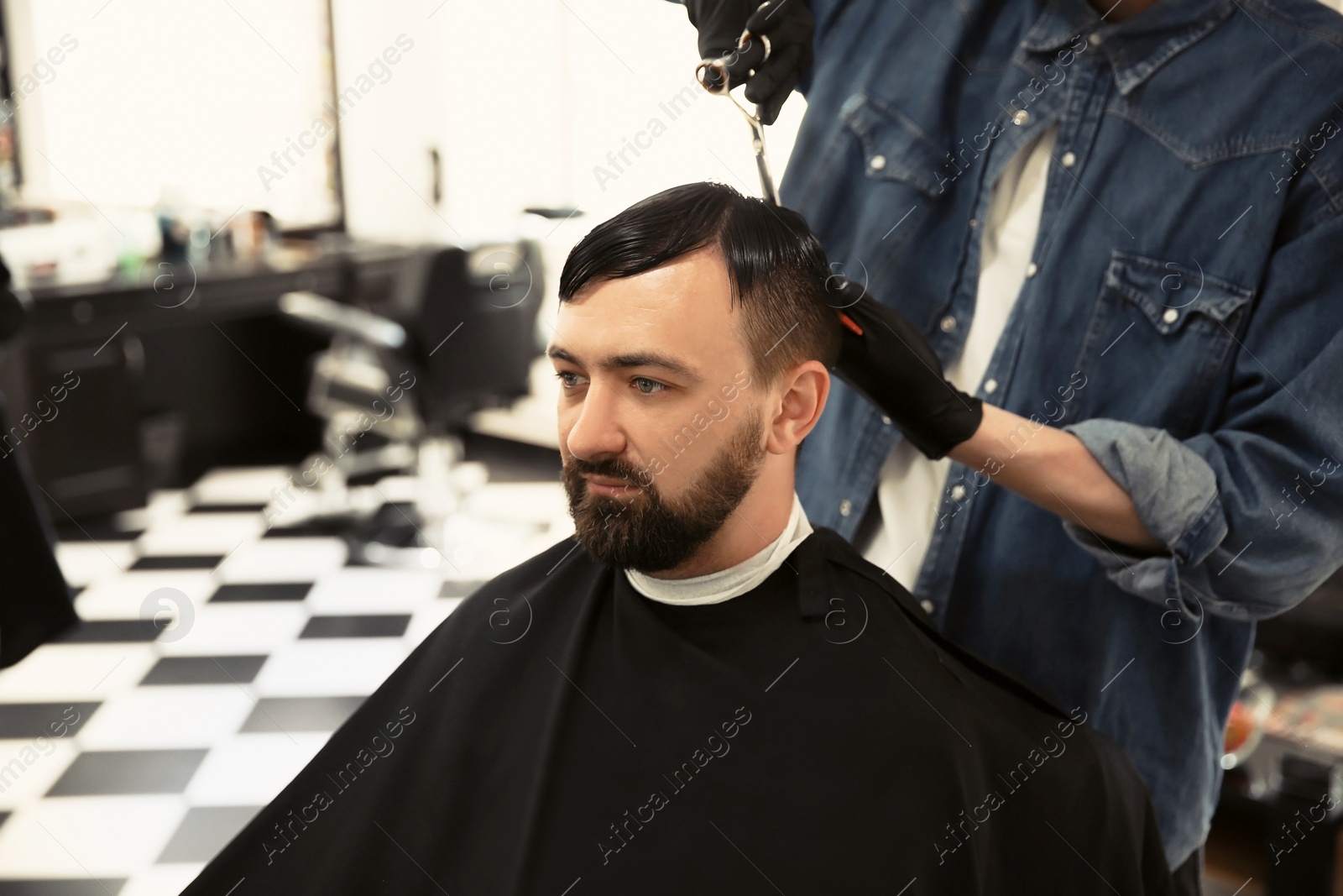 Photo of Professional barber working with client in hairdressing salon. Hipster fashion