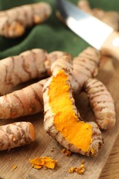 Many raw turmeric roots on table, closeup