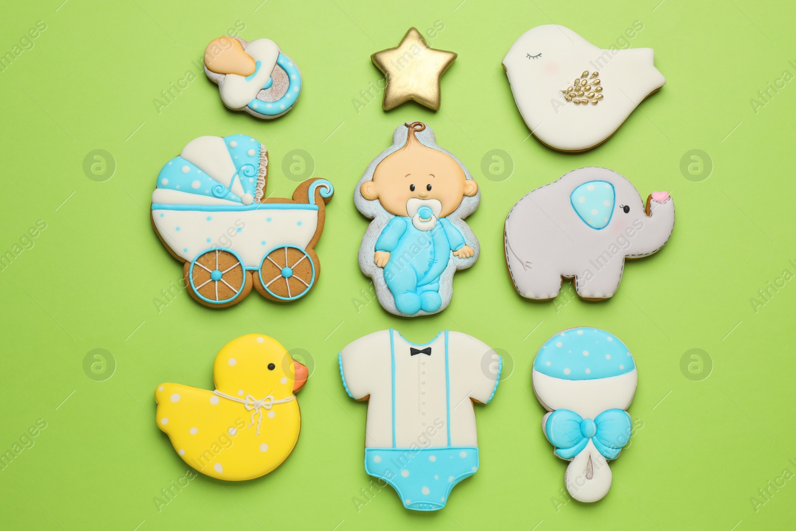 Photo of Set of baby shower cookies on light green background, flat lay