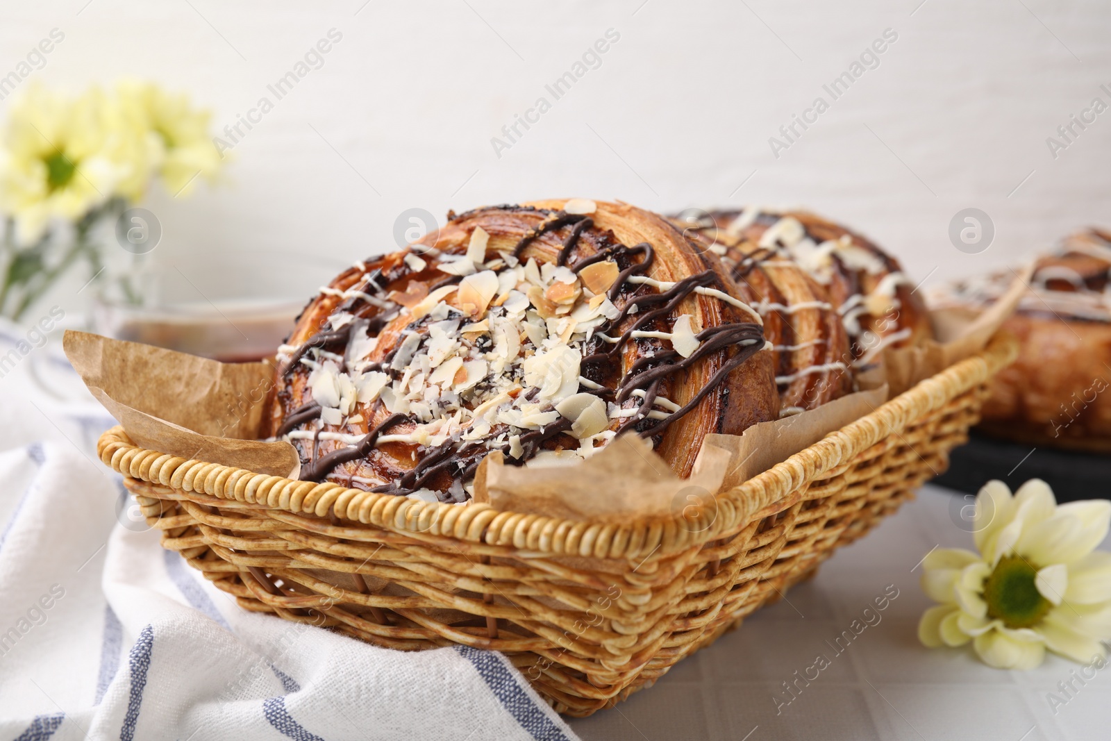 Photo of Delicious rolls with toppings and almond on white tiled table, closeup. Sweet buns